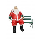 sitzender dicker Weihnachtsmann auf Bank mit Glocke und Zuckerstange