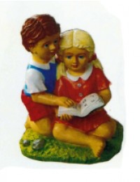 Junge und Mädchen sitzend mit Buch auf Wiese
