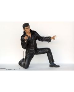 Junger hockender Elvisdouble singend mit Mikrofon lebensgroß